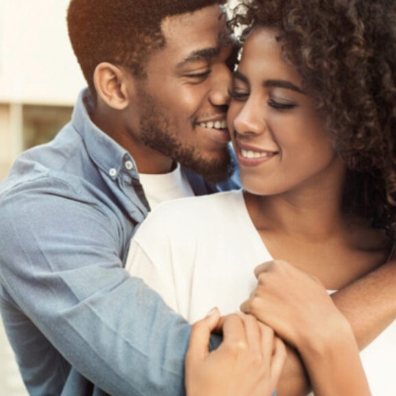 Middle aged African American cuddle hugging and smiling