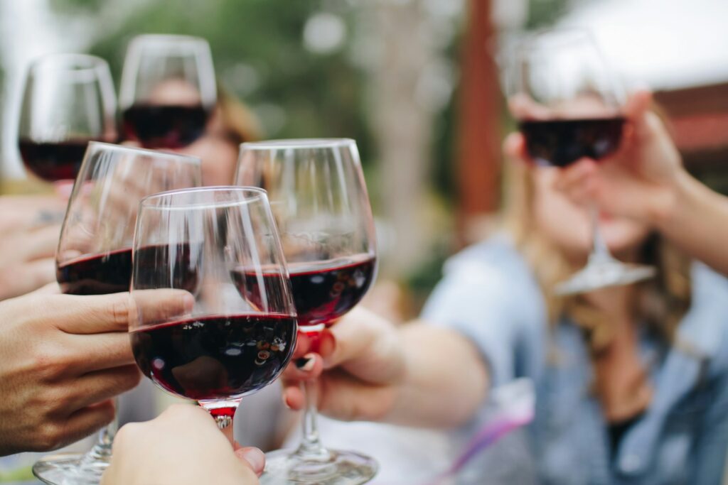 People holding a glass of wine for a toast